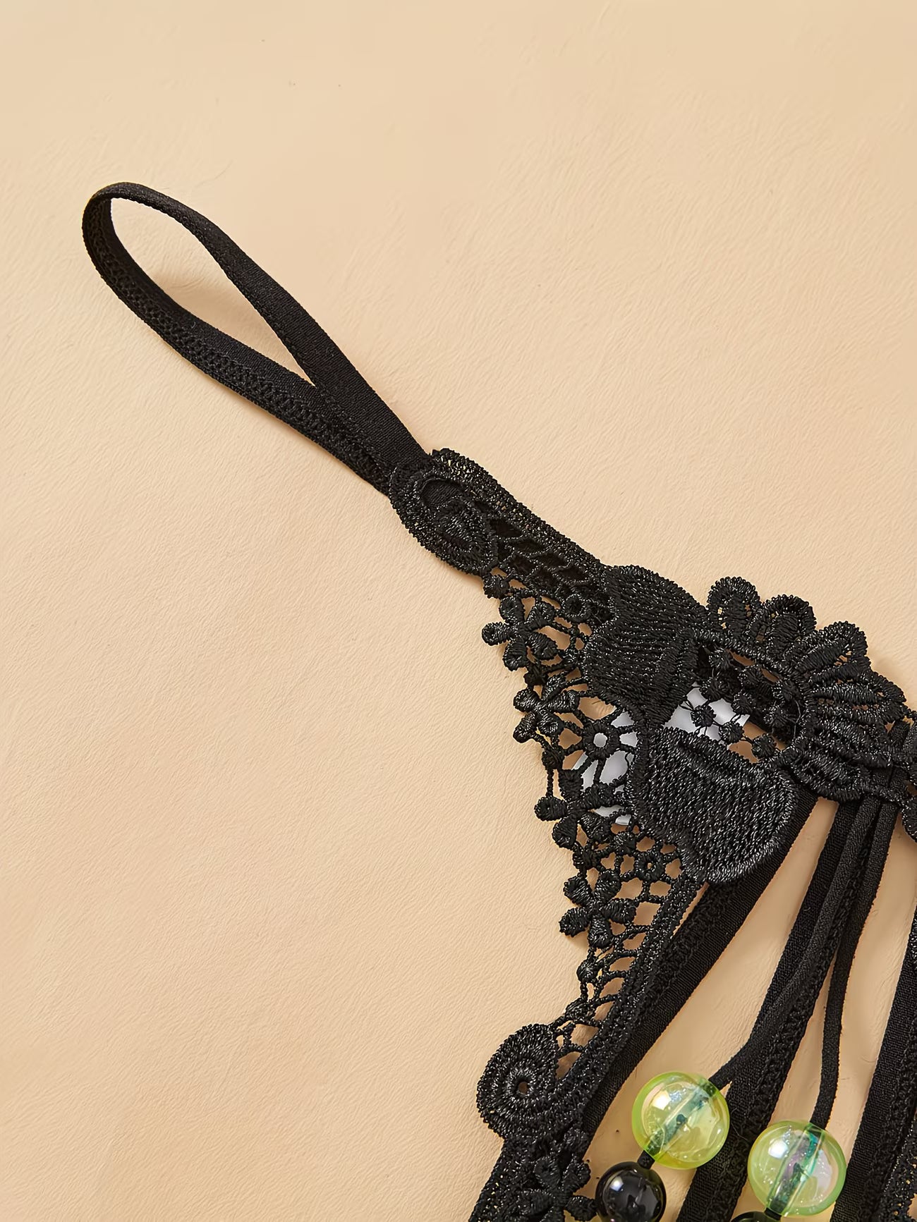 Close-up of intricate black floral lace waistband on Bikinisexzy glow-in-the-dark pearl thong panties