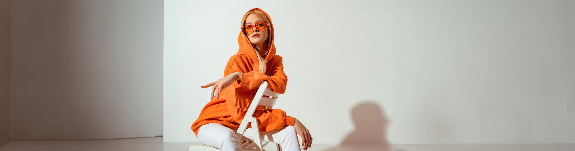 Model wearing trendy orange hoodie outfit with stylish sunglasses from BikiniSexzy collection

