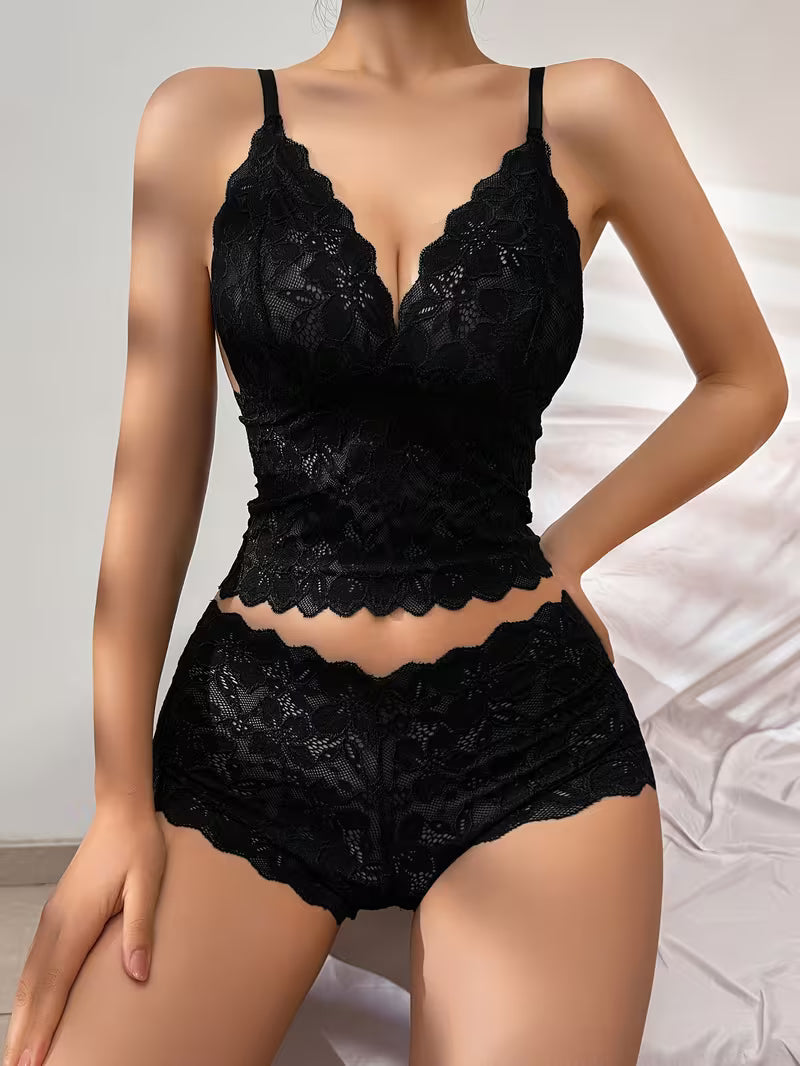 Front angle view displaying plunging deep V-neckline and scalloped lace trim on black lingerie set | Black lace lingerie set on a neutral background