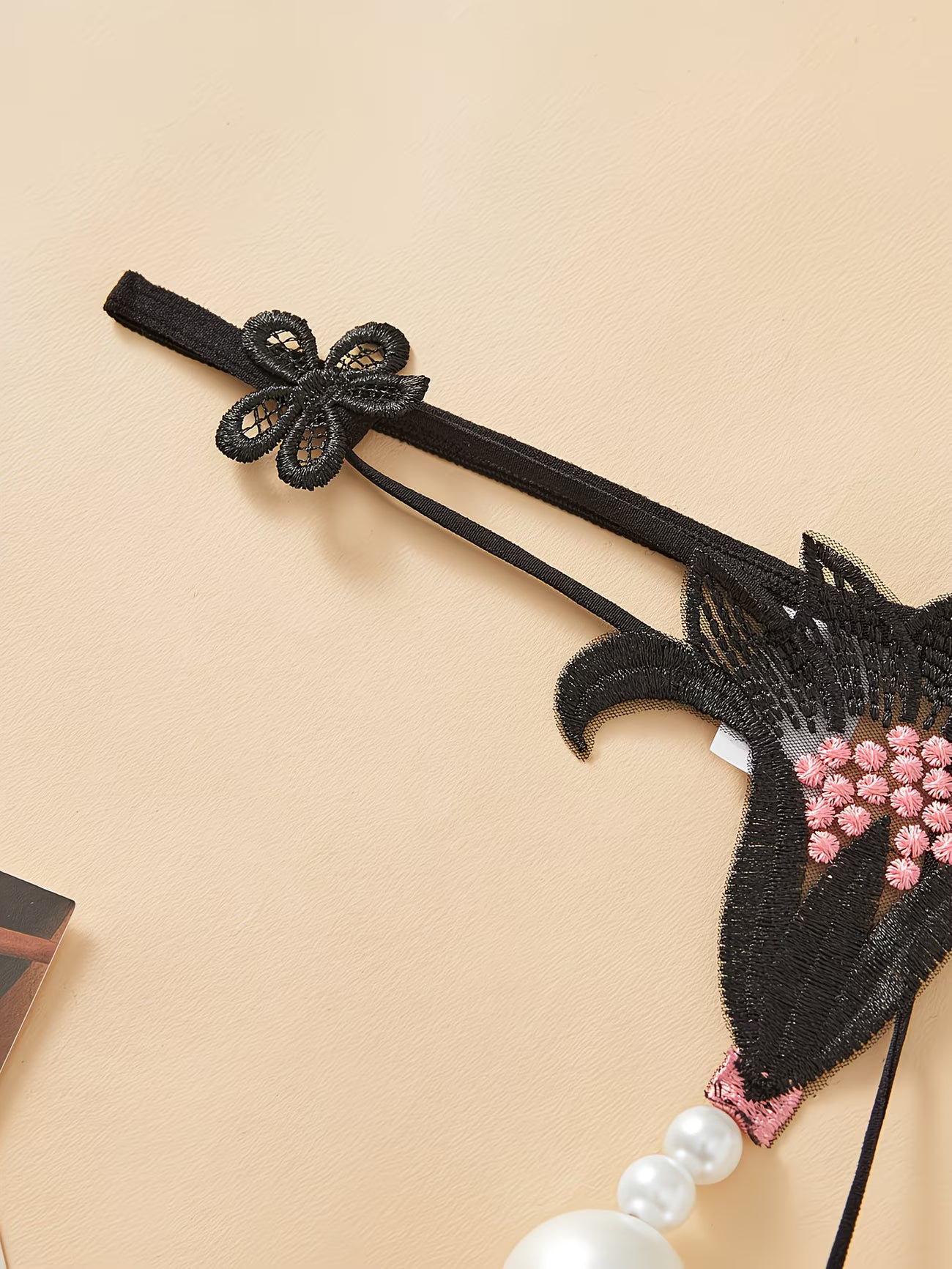 Bikinisexzy black lace thong butterfly lace side strap detail close-up showing adjustable elastic band
