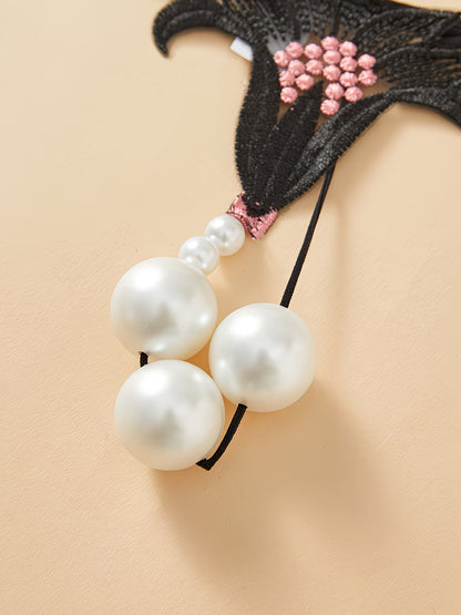 Close-up of Bikinisexzy pearl massage beads on black lace thong – 3 large white pearl spheres 1.18 inch diameter