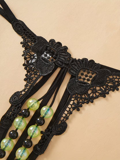 Bikinisexzy black lace open-crotch thong panties with glow-in-the-dark green and black pearl beads – front flat lay view