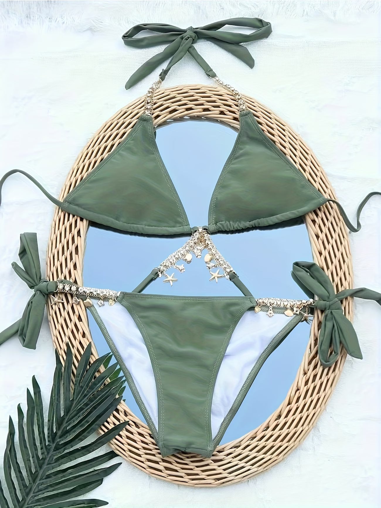Green chain charm bikini set flat lay on rattan mirror with tropical palm leaves | bikinisexzy