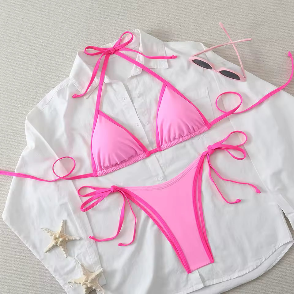 Pink bikini set with matching sunglasses on a white shirt against a neutral. BIKINISEXZY sexy halter lace up bikini set for women