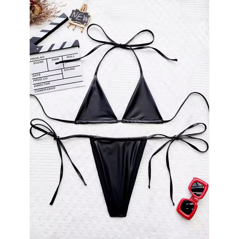 Black bikini set with red sunglasses on a white background. BIKINISEXZY bold black faux leather look bikini