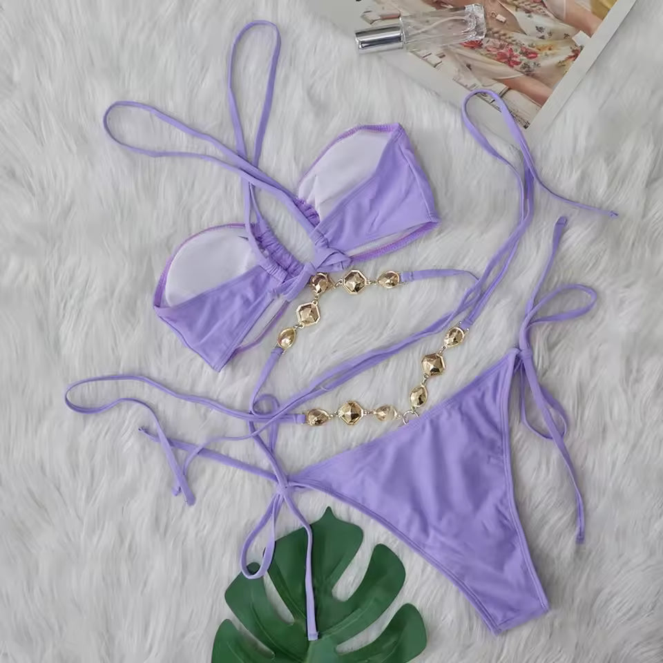 Purple bikini set with gold accents on a textured surface.BIKINISEXZY Purple Criss-Cross Halter Bikini Set
