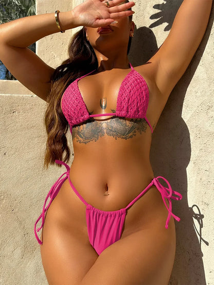 Woman wearing a pink bikini against a beige wall. Beautiful floral pattern bikini look by BIKINISEXZY