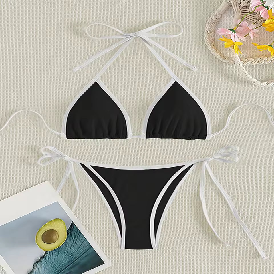 Black bikini set with white straps on a textured beige surface with flowers and BIKINISEXZY triangle thong two-piece swimsuit design