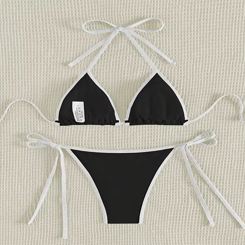 Black bikini set with white bows on a beige textured and BIKINISEXZY triangle thong two-piece swimsuit design