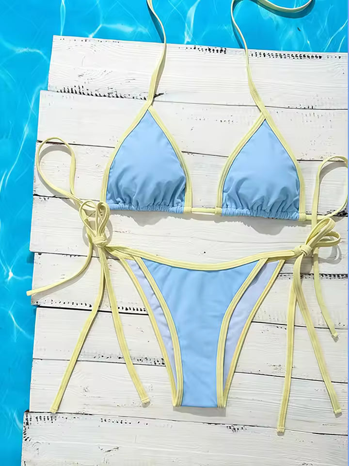 Blue bikini with yellow straps on a wooden platform by a pool. BIKINISEXZY adjustable tie side brazilian bikini set