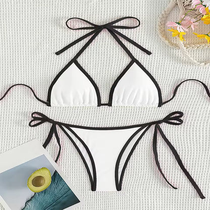 Black bikini set with bow details on a textured white surface. BIKINISEXZY tie on side sexy beach bikini set